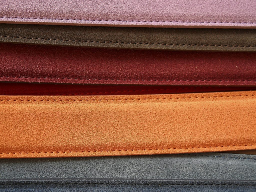Close-up of colorful leather belts showcasing detailed stitching.